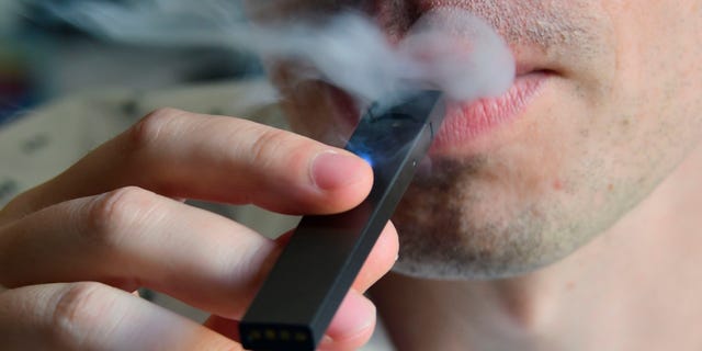 A man is shown exhaling smoke from an electronic cigarette in Washington, D.C., on Oct. 2, 2018.