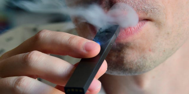 A man is shown exhaling smoke from an electronic cigarette in Washington, D.C., on Oct. 2, 2018.