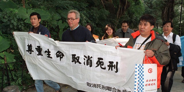 Attivisti per i diritti umani, tra cui padre Franco Mella, in viaggio per protestare contro l'uso della pena di morte per i residenti di Hong Kong in Cina al di fuori degli uffici del governo centrale.
