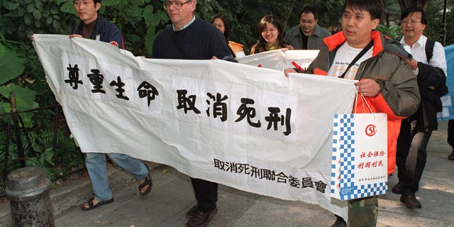 Human rights activists, including Father Franco Mella, on their way to protest against the use of the death penalty for Hong Kong residents in China outside Central Government Offices.