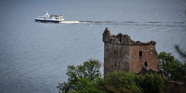 A tourist boat passes Urquhart Castle on Loch Ness in Drumnadrochit, Scotland, on September 5, 2019. 