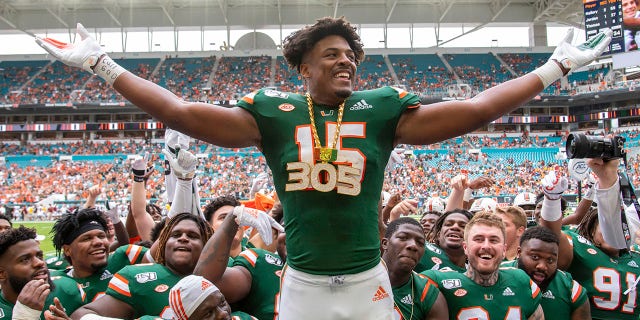 Miami Hurricanes defensive lineman Gregory Rousseau (# 15) hits Central Michigan Chippewa quarterback David Moore (# 2) during a college football match between Central Michigan Chippewa and Miami Hurricanes University. Celebrate with a UM turnover chain after bumping and collecting at Hard Rock Stadium in Miami Gardens, Florida, September 21, 2019. 