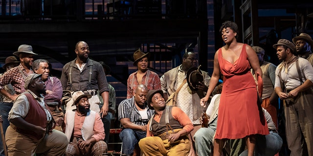 American soprano Angel Blue (as 'Bess,' standing right) and baritone Eric Owens (as 'Porgy,' seated far left with arms folded) perform at the final dress rehearsal prior to the premiere of the new Metropolitan Opera, Dutch National Opera, and English National Opera co-production of George and Ira Gershwin's and DuBose and Dorothy Heyward's 'Porgy and Bess' at the Metropolitan Opera House at Lincoln Center, New York, New York, September 19, 2019.