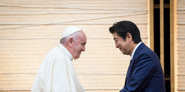 Pope Francis shakes hands with Japan's Prime Minister Shinzo Abe during a meeting with the diplomatic community at the prime minister's office Nov. 25, 2019, in Tokyo. 