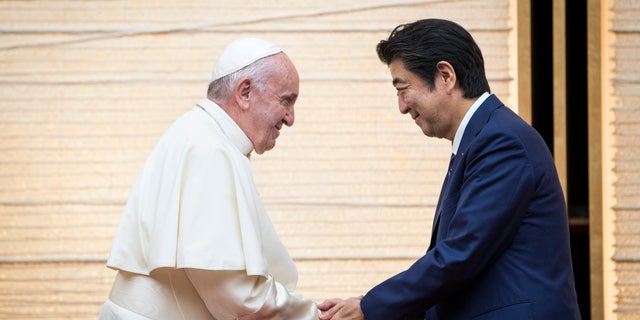 Pope Francis shakes hands with Japan's Prime Minister Shinzo Abe during a meeting with the diplomatic community at the prime minister's office Nov. 25, 2019, in Tokyo.