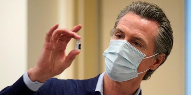 Gov. Gavin Newsom holds up a vial of the Pfizer-BioNTech COVID-19 vaccine. (Photo by Jae C. Hong-Pool/Getty Images)