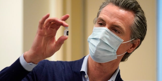 Gov. Gavin Newsom holds up a vial of the Pfizer-BioNTech COVID-19 vaccine. (Photo by Jae C. Hong-Pool/Getty Images)