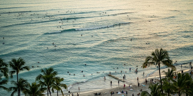 HONOLULU, HI - JUNE 26: The sun sets off of Waikiki Beach on the Hawaiian island of Oahu on Saturday, June 26, 2021 in Honolulu, HI. (Kent Nishimura / Los Angeles Times via Getty Images)