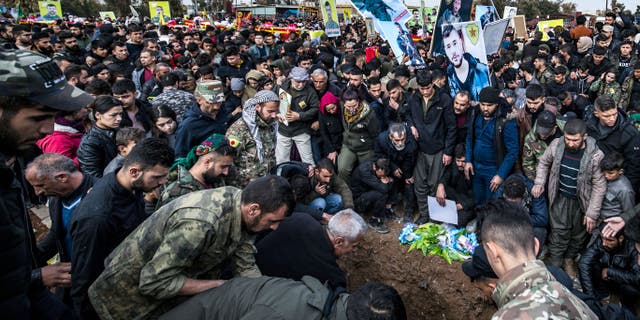 People take part in a funeral in the Kurdish-majority city of Qamishli in Syria's northeastern Hasakeh province on February, 2, 2022, for Syrian Democratic Forces (SDF) fighters killed in clashes during a jailbreak attempt by the Islamic State (IS) group at the Ghwayran prison in the province.