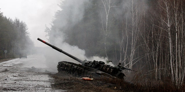 Smoke rises from a Russian tank destroyed by Ukrainian forces on the side of a road in the Lugansk region.