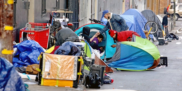 Homeless people consume illegal drugs in an encampment along Willow St. in the Tenderloin district of downtown on Thursday, Feb. 24, 2022 in San Francisco, CA.