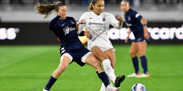 Washington Spirit defender Kelley O'Hara, left, and North Carolina Courage defender Jaelene Hinkle Daniels fight for a ball during an NWSL game March 30, 2022, at Audi Field in Washington, D.C. 