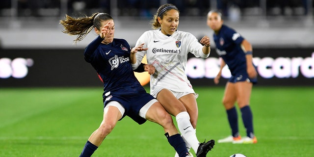 Washington Spirit defender Kelley O'Hara, left, and North Carolina Courage defender Jaelene Hinkle Daniels fight for a ball during an NWSL game March 30, 2022, at Audi Field in Washington, D.C. 