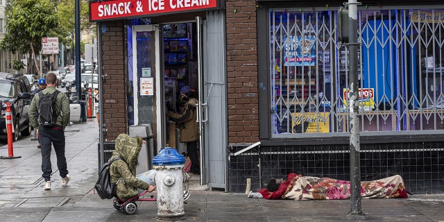 A person experiencing homelessness sleeps on the sidewalk in the Tenderloin district of San Francisco, California, U.S., on Thursday, April, 14, 2022. San Francisco was home to more than 9,800 unhoused people as of the last released count in 2019, up more than 30% from two years earlier, according to a city point-in-time estimate that is likely a significant undercount. 