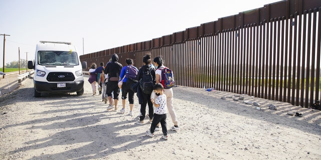 Asylum seekers board a CBP transport van after entering the United States in Yuma Arizona., May 20, 2022 