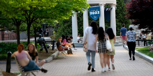 A Class of 2022 banner is displayed as students walk on campus at George Washington University in Washington, DC, on May 2, 2022. (Photo by Stefani Reynolds / AFP) (Photo by STEFANI REYNOLDS/AFP via Getty Images)