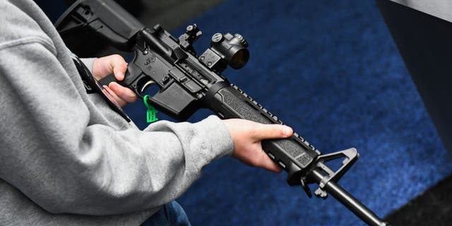 An attendee holds a Springfield Armory SAINT AR-15 style rifle displayed during the National Rifle Association (NRA) Annual Meeting at the George R. Brown Convention Center, in Houston, Texas on May 28, 2022.