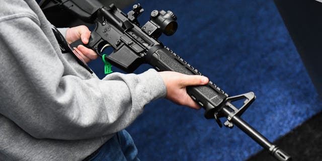 An attendee holds a Springfield Armory SAINT AR-15 style rifle displayed during the National Rifle Association (NRA) Annual Meeting at the George R. Brown Convention Center, in Houston, Texas on May 28, 2022.