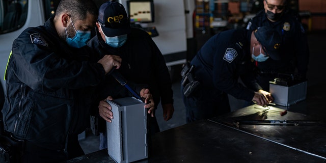 U.S. Customs and Border Protection (CBP) officers inspect a shipment of car batteries.