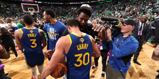 Stephen Curry # 30 and Andrew Wiggins # 22 from the Golden State Warriors hug after Game 6 of the 2022 NBA Finals at TD Garden in Boston, Massachusetts on June 16, 2022.