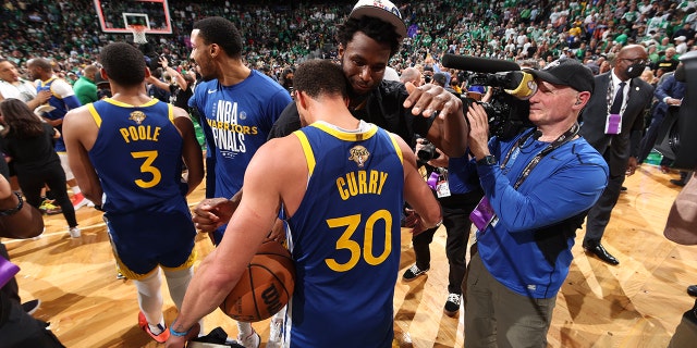 Stephen Curry #30 and Andrew Wiggins #22 of the Golden State Warriors embrace after Game Six of the 2022 NBA Finals on June 16, 2022, at TD Garden in Boston, Massachusetts.