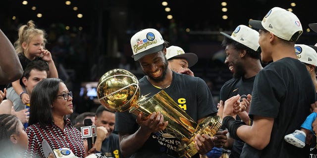 Andrew Wiggins, #22 of the Golden State Warriors, celebrates with The Larry O'Brien trophy after Game Six of the 2022 NBA Finals on June 16, 2022 at TD Garden in Boston, Massachusetts. 