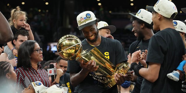 Andrew Wiggins of the Golden State Warriors celebrates with The Larry O'Brien Trophy after Game 6 of the 2022 NBA Finals June 16, 2022, at TD Garden in Boston.