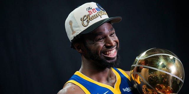 Andrew Wiggins of the Golden State Warriors will pose for a portrait at the Larry O'Brien Championship Trophy after winning Game 6 of the 2022 NBA Finals on June 16, 2022 at TD Garden in Boston, Massachusetts. 