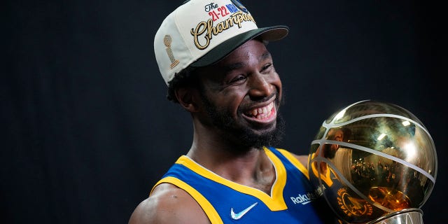 Andrew Wiggins of the Golden State Warriors poses for a portrait with the Larry O'Brien championship trophy after winning game six of the 2022 NBA Finals at TD Garden on June 16, 2022 in Boston, Massachusetts. 