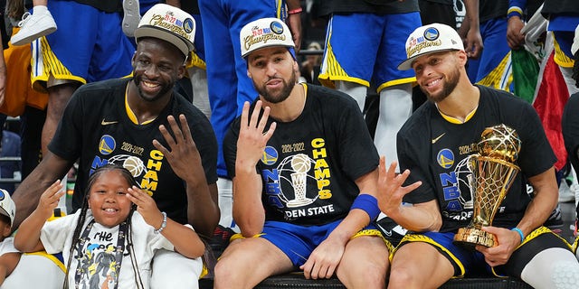 The Golden State Warriors pose for a photo with the Bill Russell NBA Finals MVP Award after Game 6 of the 2022 NBA Finals on June 16, 2022, at TD Garden in Boston, Massachusetts.