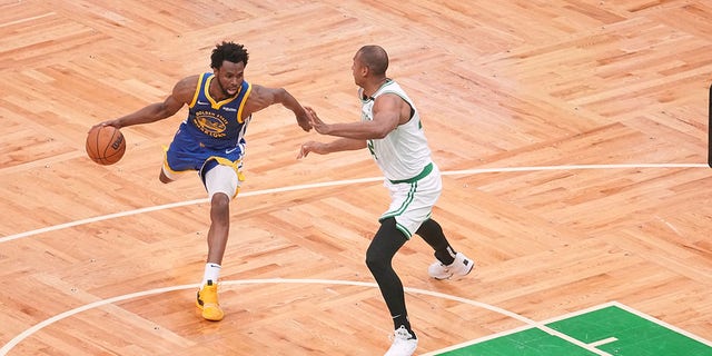 Golden State Warriors Andrew Wiggins, No. 22, in action, dribbling against Boston Celtics Al Horford, No. 42, at TD Garden.  Game 6 of the 2022 NBA Finals.