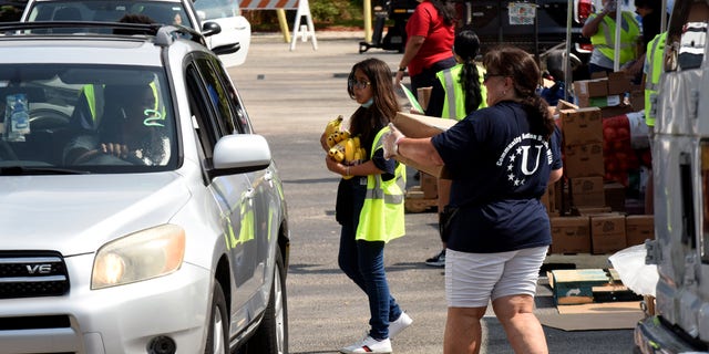 Orlando, FL: Volunteers provide bananas and other foods to the needy at a food distribution event sponsored by the Second Harvest Food Bank of Central Florida and Orange County at St. John Bianni Church in Orlando, Florida. 