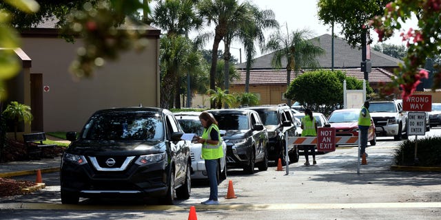Cars are shown lined up to enter a food distribution event for the needy sponsored by the Second Harvest Food Bank of Central Florida and Orange County at St. John Vianney Church in Orlando, Florida.