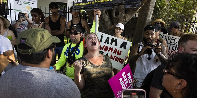 Kürtaj hakları göstericileri ve kürtaj karşıtı bir gösterici, 26 Haziran 2022 Pazar günü Austin, Teksas'taki üreme özgürlüğü mitinginin ardından tartışıyor.