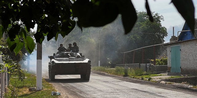 Ukrainian soldiers ride an armoured vehicle on the main road to Lysychansk in Ukraine's eastern region of Donbas on June 26, 2022. 