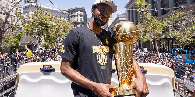 Andrew Wiggins of the Golden State Warriors holds the Larry O'Brien Championship Trophy during their 2022 Victory Parade Rally on June 20, 2022, at Chase Center in San Francisco, California.