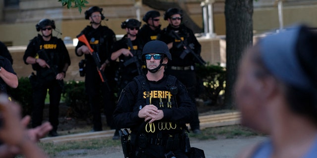 Members of the Sheriff department in riot gear stand by as demonstrators gather outside Akron City Hall to protest the killing of Jayland Walker, shot by police, in Akron, Ohio, July 3, 2022. -