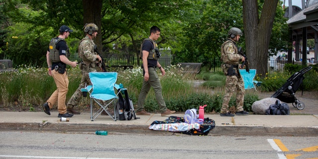 Law enforcement officers work on the scene after a mass shooting at a July 4 parade near Chicago.