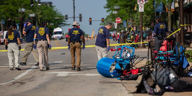 FBI agents work the scene of a shooting at a Fourth of July parade on July 5, 2022, in Highland Park, Illinois. Police have detained Robert "Bobby" E. Crimo III, 21, in connection with the shooting.