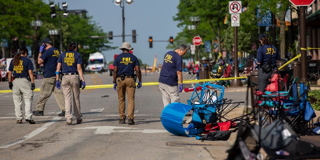 FBI agents work the scene of a shooting at a Fourth of July parade on July 5, 2022 in Highland Park, Illinois. Police have detained Robert "Bobby" E. Crimo III, 22, in connection with the shooting in which six people were killed and 19 injured, according to published reports.