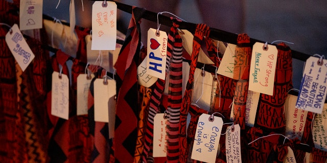 People add strips of cloth with names and phrases memorializing the victims at a vigil near the scene of a mass shooting yesterday at a Fourth of July parade, on July 5, 2022 in Highland Park, Illinois.