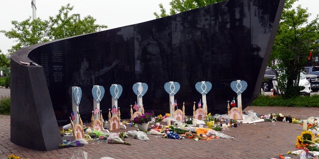 People lay flowers and cards near a spot where a mass shooting took place during the 4th of July parade in Highland Park, Illinois.