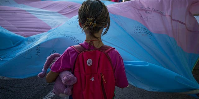 A girl holds the Transgender Pride flag during the pride march in Madrid on July 9, 2022.