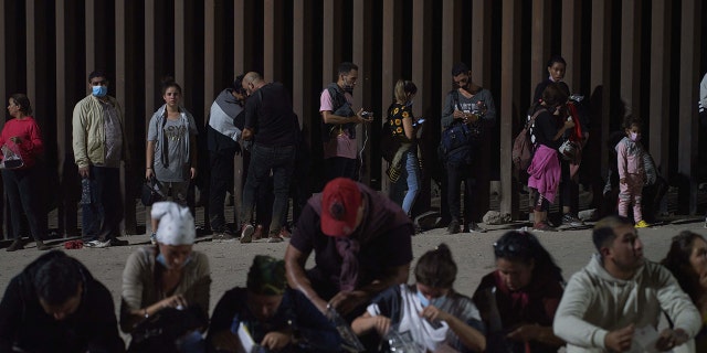 Migrants wait to be processed by the Border Patrol after illegally crossing the US-Mexico border in Yuma, Arizona, in the early morning of July 11, 2022.