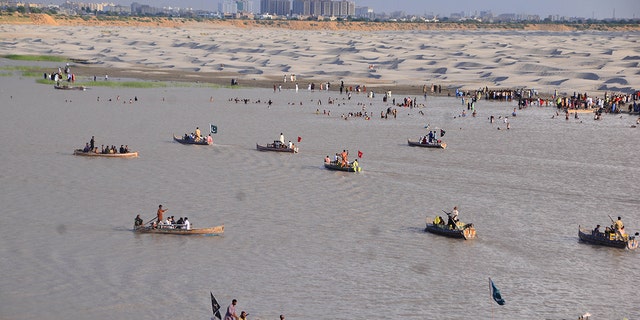 Hyderabad, Pakistan-July 12: Pakistan people on the banks of Pakistan's largest Indus River in Hyderabad, southern Sindh, Pakistan, July 12, 2022.