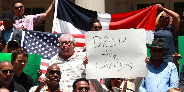 Members of the Dominican Republic community, bodega owners and members of various associations pose for photos on the steps of City Hall during a press conference calling on Manhattan's DA Alvin Bragg to drop the charges against bodega worker Jose Alba. I'm here.