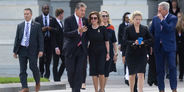 WASHINGTON - LUGLIO 14: Il senatore Joe Manchin (D-W.V.) embraces House Speaker Nancy Pelosi (D-Calif.) before watching the departure of the casket of Herschel Woody Williams on Capitol Hill in Washington, D.C., di giovedì, luglio 14, 2022. Williams, who passed away at the age of 98, laid in honor inside in the Capitol. (Photo by Tom Brenner for The Washington Post via Getty Images)