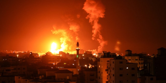 Fires are seen following an Israeli airstrike in Gaza city on July 16, 2022. - Israeli warplanes struck a weapons manufacturing facility in the Gaza Strip early on July 16, the military said, after rocket fire against Israeli territory. (Photo by Mahmud HAMS / AFP) 