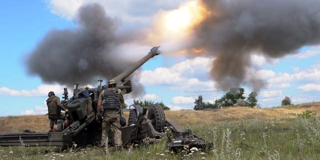 Ukrainian servicemen fire a towed howitzer in eastern Ukraine. 