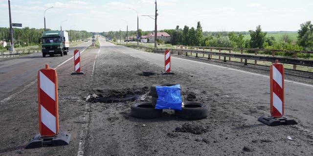 A picture taken on July 21, 2022 shows craters on Kherson's Antonovsky bridge across the Dnipro river caused by a Ukrainian rocket strike, amid the ongoing Russian military action in Ukraine.